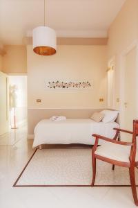 a bedroom with two beds and a chair at L'ARENA B&B in Santa Maria Capua Vetere