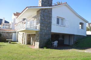 uma casa branca com uma varanda e uma mesa em Los Sargos em Punta del Este