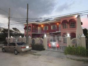 a house with a car parked in front of it at The Residence Portmore Apartments in Portmore