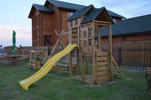 a wooden playground with a slide and a house at Pulemchanka in Pulemets