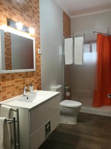 a bathroom with a sink and a toilet and a mirror at Zesty Orange by ITHOUSE in Albufeira