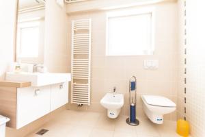 a white bathroom with a toilet and a sink at Apartma in Ormoz
