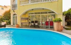 a swimming pool in front of a house at Apartments Dora in Medulin