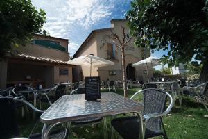 a table with an umbrella and chairs in a yard at Crux Albergue in Adahuesca