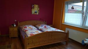 a wooden bed in a room with a window at Wohnung 3 mit Terrasse Haus Annegrete in Bensersiel