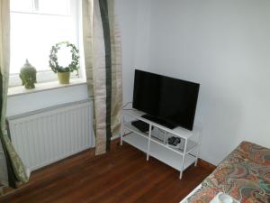 a flat screen tv on a white stand in a living room at FeWo Rhoen-Thal in Gersfeld