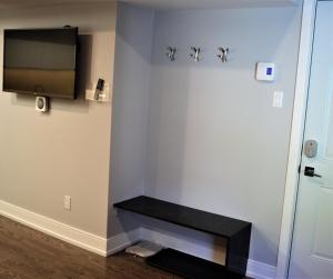 esquina de una habitación con TV y banco en Simply Luxury Stays, en Ottawa