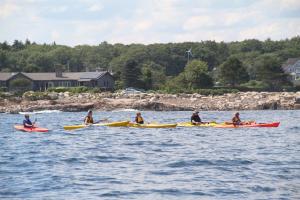 people on surfboards in a body of water at Rhumb Line Resort in Kennebunkport
