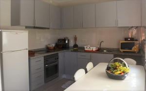 a kitchen with a table with a bowl of fruit on it at Casa Praia Norte - PVZ in Póvoa de Varzim