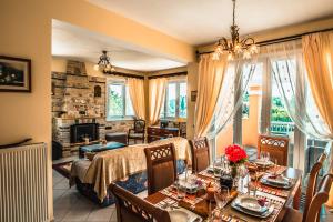 a dining room with a table and chairs and a living room at Villa Miranda in Corfu