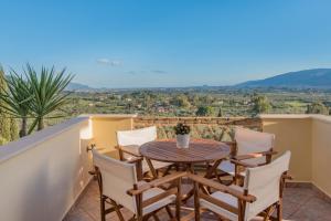 a table and chairs on a balcony with a view at Villas Lugrezia Sea View in Meson Yerakarion