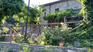 un edificio in pietra con una recinzione e alcune piante di Agriturismo Masseria Tufaro ad Albidona