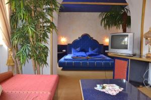 a bedroom with a blue bed and a tv at Gasthof Kemmetmüller in Windischgarsten
