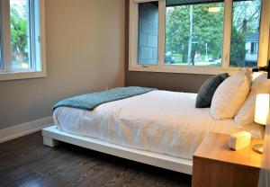 a bedroom with a bed and two windows at Simply Luxury Stays in Ottawa