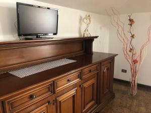 a flat screen tv sitting on top of a wooden entertainment center at Apartment La Terrazza in Orio al Serio