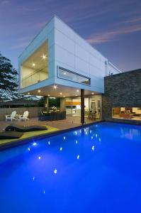 a house with a blue swimming pool in front of it at Hidden Paradise in Gold Coast