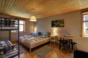 een slaapkamer met een stapelbed, een tafel en een bureau bij Pilava in Roja