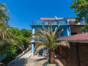 a house with a palm tree in front of it at Apartments LUMAR in Dramalj