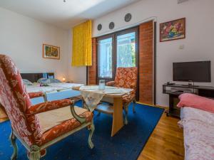 a living room with a table and chairs and a tv at Apartments LUMAR in Dramalj