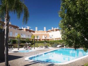 a swimming pool in front of a large building at Cabanas Garden By HnM in Cabanas de Tavira