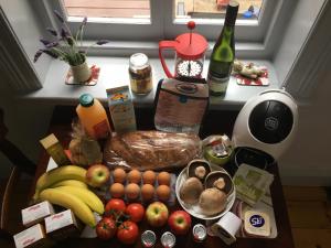 a kitchen counter with fruits and vegetables and a table with food at bluebird cottage in Angaston
