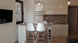 a kitchen with two white stools at a counter at Zlatibor Wood in Zlatibor