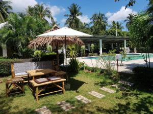 un tavolo da picnic e un ombrellone accanto a una piscina di Happy Mind Resort a Sam Roi Yot