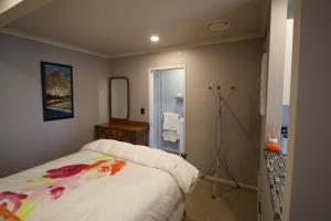 a bedroom with a bed and a mirror at The Red Hen And Dog in Ohope Beach