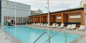 a large swimming pool with white chairs and a building at Luxury condo on CN TOWER in Toronto