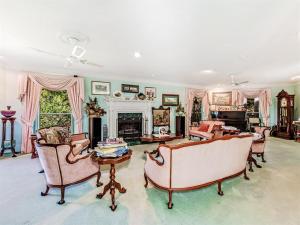 a large living room with chairs and a fireplace at Noosa Hinterland Spectacular Boutique Guesthouse in Cooran