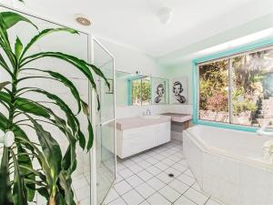 ein Badezimmer mit einer Badewanne, einem WC und einer Pflanze in der Unterkunft Noosa Hinterland Spectacular Boutique Guesthouse in Cooran