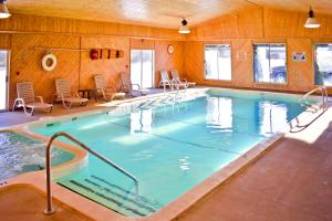a large swimming pool with chairs in a building at Americas Best Value Inn & Suites - Tahquamenon Country in Newberry