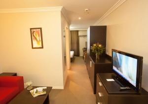 a living room with a red couch and a television at Wine Country Motor Inn in Cessnock