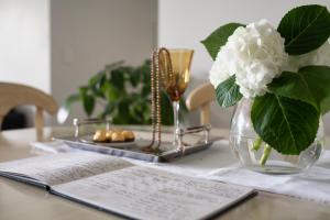 une table avec un vase de fleurs et un livre dans l'établissement Andelin Guest House, à Auckland