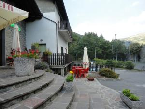 een patio met tafels en parasols naast een gebouw bij Residence Il Mulinaccio in Pievepelago +41 foto's