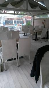 patio z białymi krzesłami, stołami i parasolem w obiekcie Hotel Hawaii w Łozencu