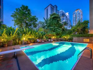 a swimming pool with a city skyline in the background at Bangkok ShortStay, 2-3BR SUKHUMVIT in Bangkok