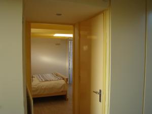 a room with a bed and a door leading to a bedroom at B&B Zuiderkreek in De Cocksdorp