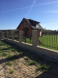 a fence in front of a house at Lavender Cottage in Charzykowy