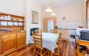a dining room with a table and a kitchen at Eliza 1875 Red Brick Duplex Townhouse in Grafton