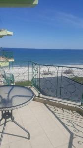 a table and chair on a balcony with a view of the beach at Apartament Safir Mamaia in Mamaia