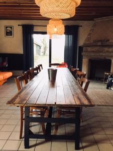 un tavolo in legno con sedie in una stanza con camino di Gîte du Mont de la Louve a Bazinghen