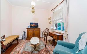 a living room with a blue couch and a table at Azile 1875 Heritage Victorian Duplex in Grafton