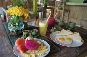 uma mesa coberta com pratos de alimentos e bebidas ao pequeno-almoço em Kuda Laut Bungalows & Diving em Pemuteran