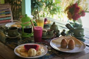 佩母德兰库达劳特简易别墅与潜水度假酒店的餐桌,盘子上放着食物,杯子和饮料