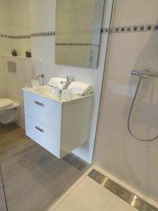 biała łazienka z umywalką i prysznicem w obiekcie La petite Maison w Grenoble