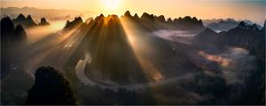 a group of rays of light shining on mountains at Yangshuo Yunshe Mountain Guesthouse in Yangshuo