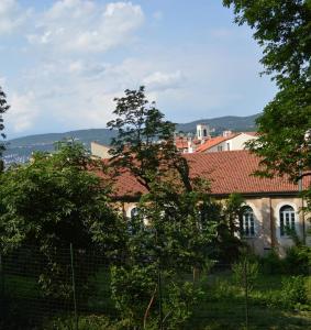 a building with a red roof and some trees at Casa Vacanze All'angolo in Trieste