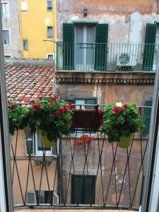 a balcony with red flowers on a building at LeopardElla in Rome