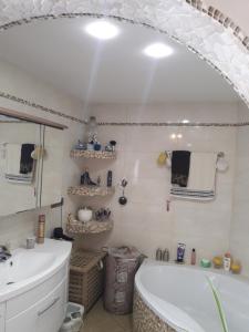 ein Badezimmer mit einer Badewanne und einem Waschbecken in der Unterkunft Gemütliche Zimmer in Kaisersesch